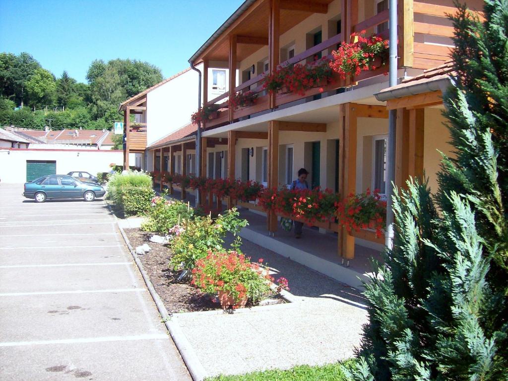 um edifício com caixas de flores ao lado em Hotel Restaurant De La Canner em Kédange-sur-Canner