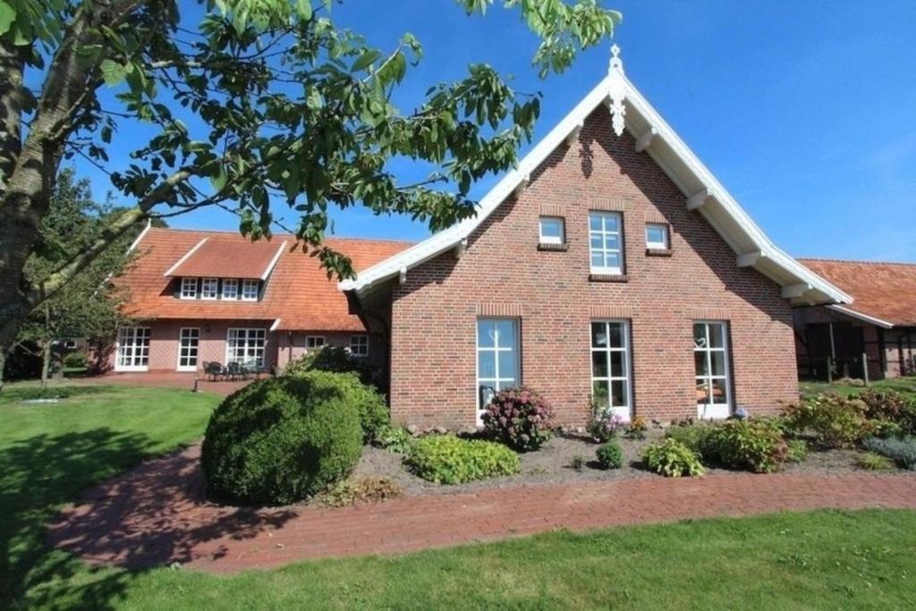 a brick house with a landscaping at Naturhof Buschwiesen - Wohnung Nandu in Wilsum