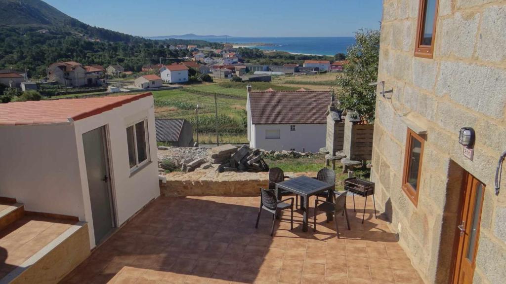 a small patio with a table and chairs on a balcony at Casa Florinda Casa con terraza in Lariño