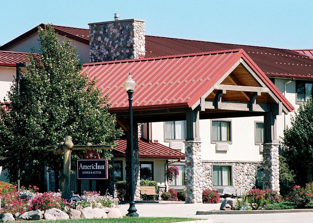 ein Hotel mit rotem Dach und einem Schild davor in der Unterkunft AmericInn by Wyndham Oswego in Oswego