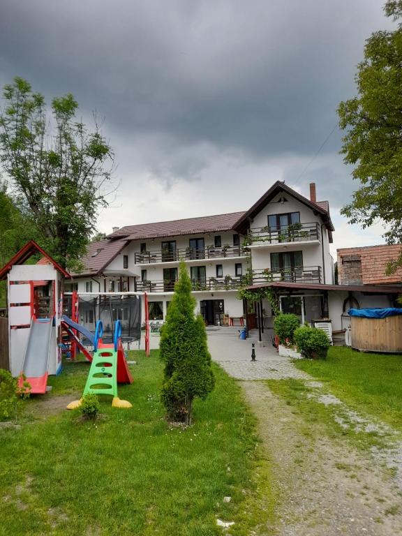 an apartment building with a playground in the yard at Casa Tican in Bran