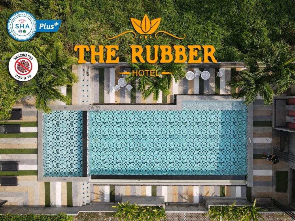 a hotel with a swimming pool in front of a building at The Rubber Hotel - SHA Extra Plus in Thalang