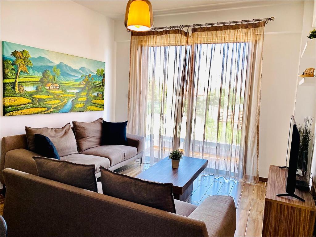 a living room with a couch and a table at BALI SUITES 202 in Larnaca