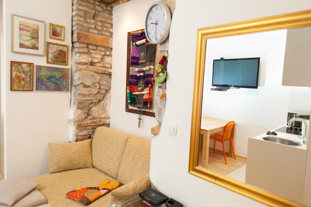 ein Wohnzimmer mit einem Spiegel und einem Stuhl in der Unterkunft Apartment Stara vrata in Rijeka