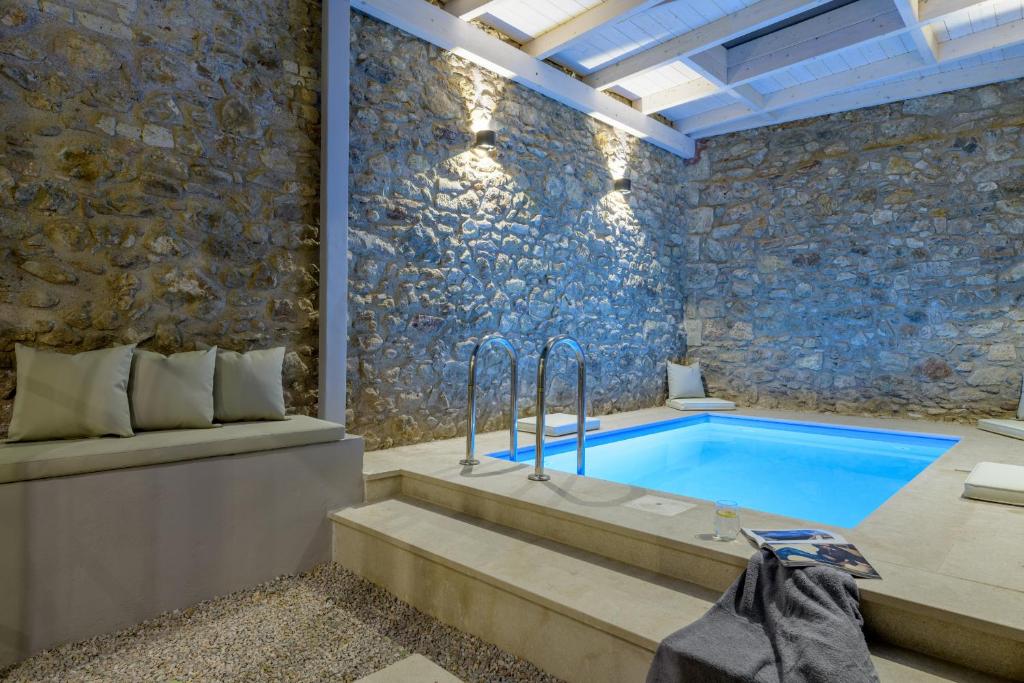 a bathroom with a plunge pool and a stone wall at Incomparable Plaka's Luxury Apt Private Pool in Athens