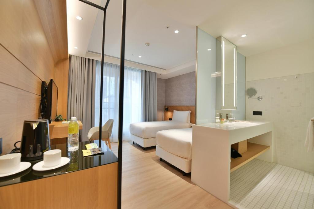 um quarto de hotel com uma cama e um lavatório em CHECK inn Select New Taipei Sanchong em Taipei