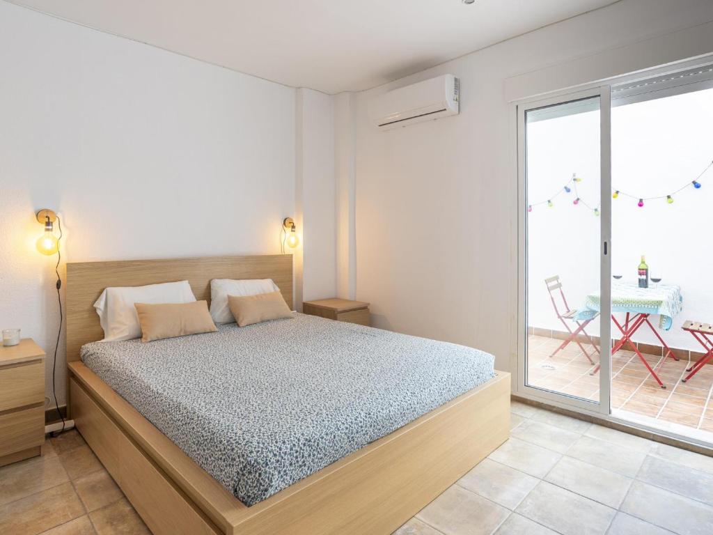 a bedroom with a bed and a large window at LU&CIA Calle Agua in Málaga