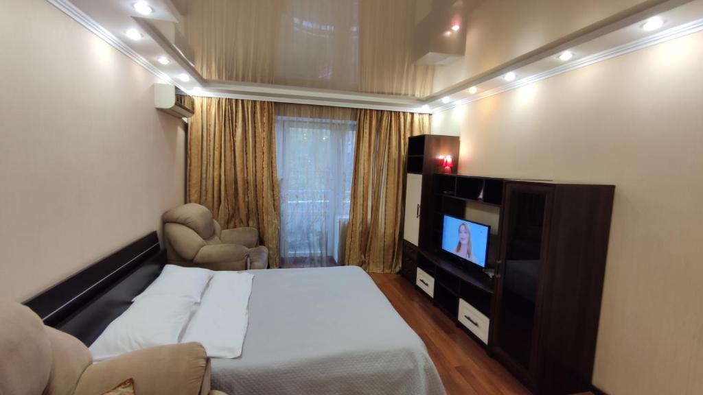 キーウにあるKyivStay Pochaynynska Apartmentのベッドとテレビが備わるホテルルームです。