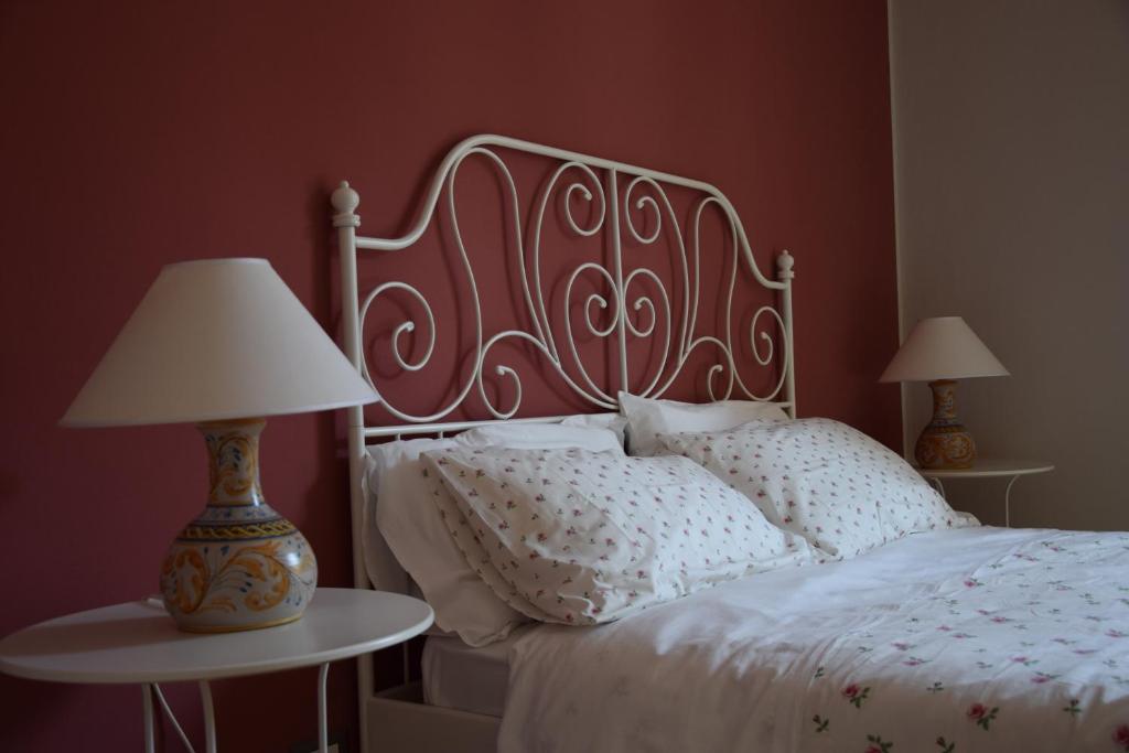 a bedroom with a white bed and two tables with lamps at B&B Le Coppole in Palermo