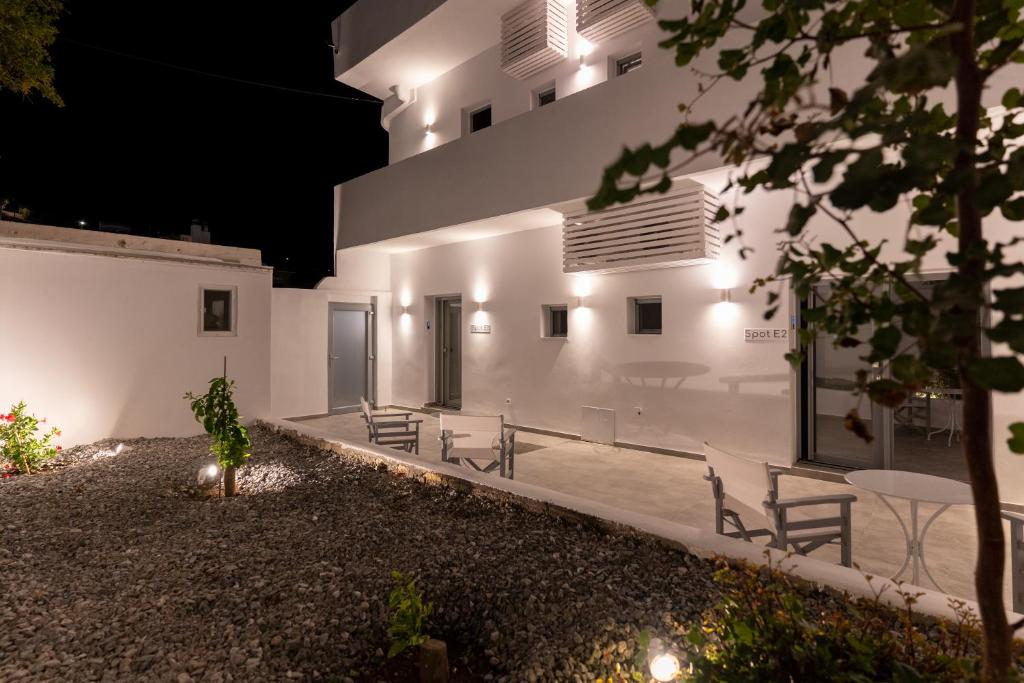 a house with white walls and a courtyard at night at Bedspot Apartments Astipalaia in Pera Gyalos