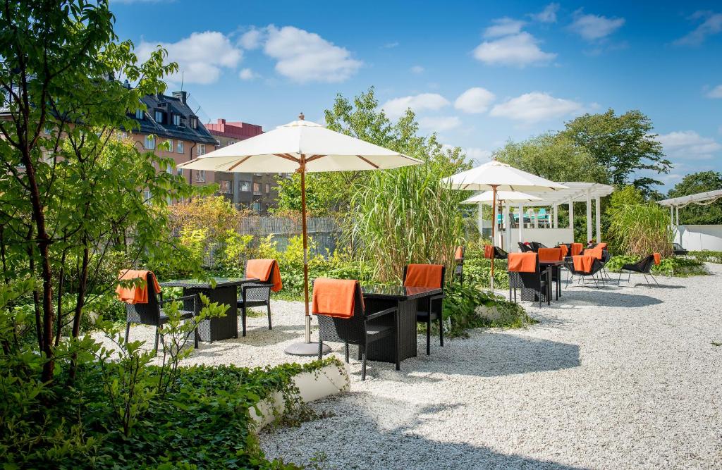 een rij tafels en stoelen met parasols bij Elite Hotel Arcadia in Stockholm