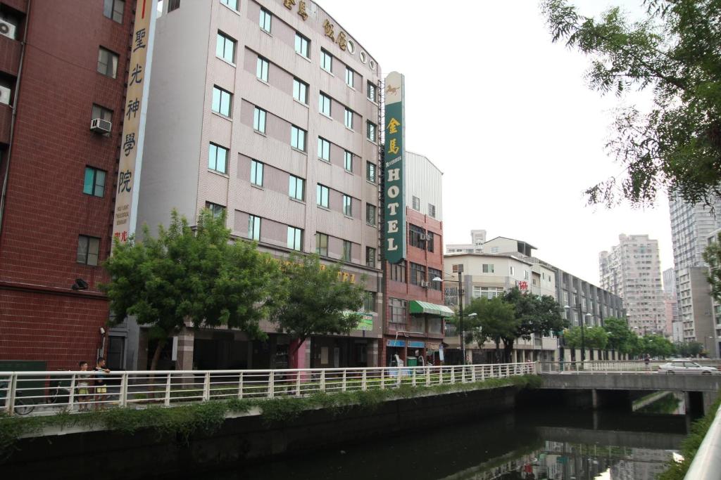 a building next to a river in a city at Riverside Hotel in Kaohsiung