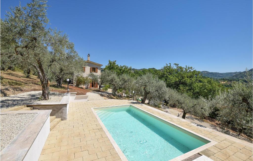 een zwembad in een tuin met bomen en een huis bij Stunning Home In Toffia With Outdoor Swimming Pool in Toffia