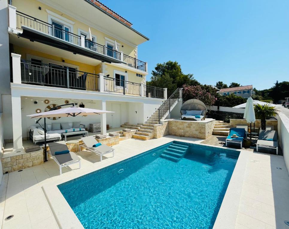 uma villa com uma piscina e uma casa em Villa Lemony em Maslinica