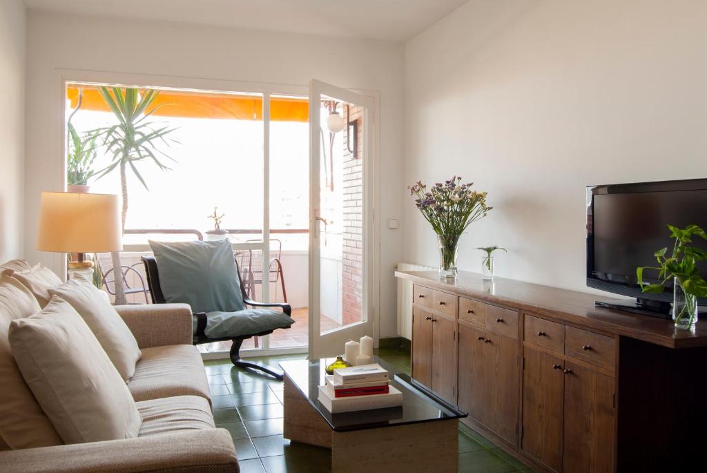 a living room with a couch and a flat screen tv at Apartment near the beach and Port Marina of Premia in Premiá de Mar