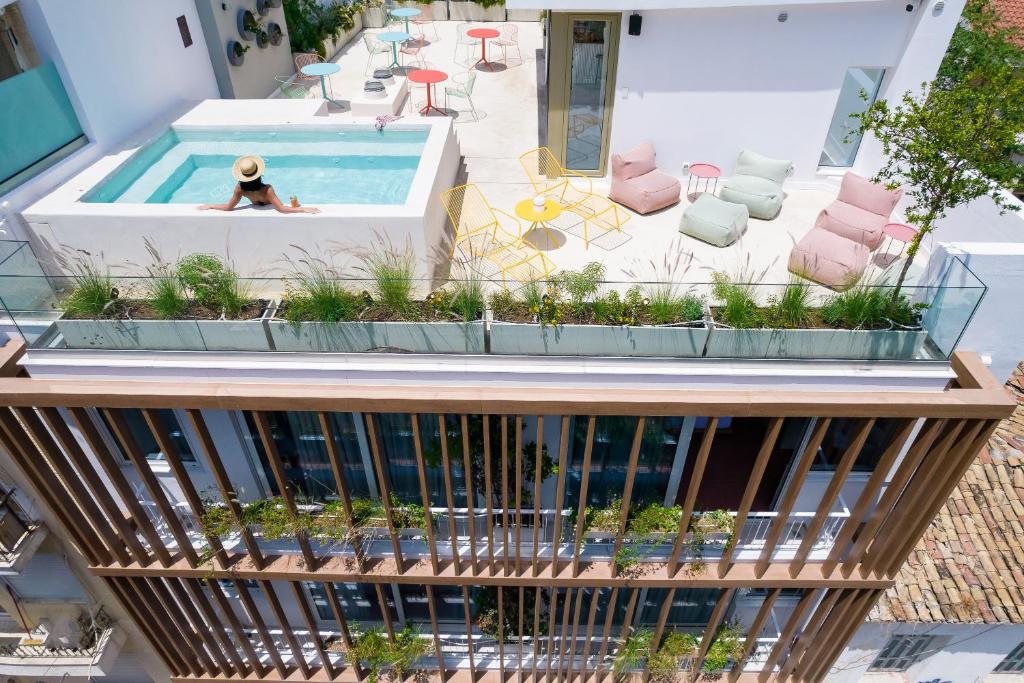 kobieta leżąca w basenie na dachu budynku w obiekcie Alkima Athens Hotel w Atenach