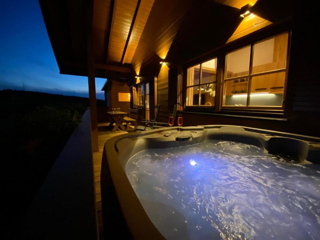 a bath tub in front of a house at night at Chalet Leithenwald in Zwiesel