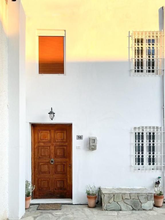 a white building with a wooden door and windows at Casa Bianca Elegant House Near Beach in Spetses