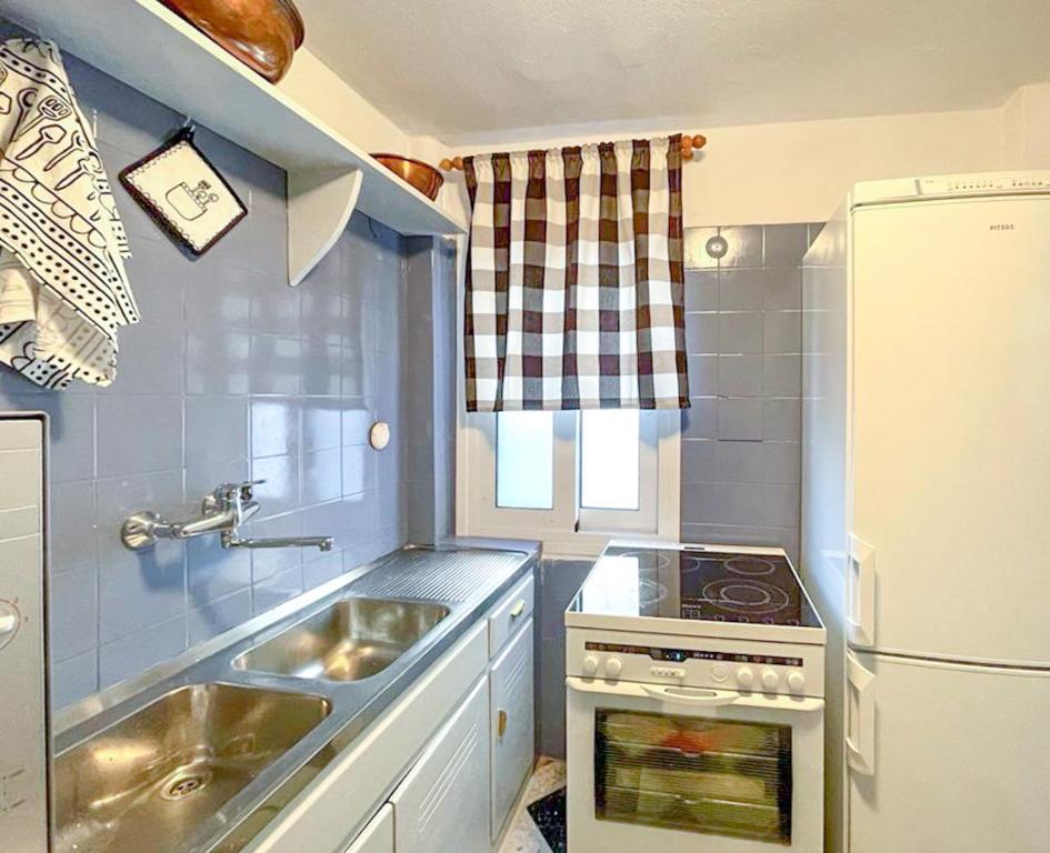 a small kitchen with a sink and a refrigerator at Casa Bianca Elegant House Near Beach in Spetses