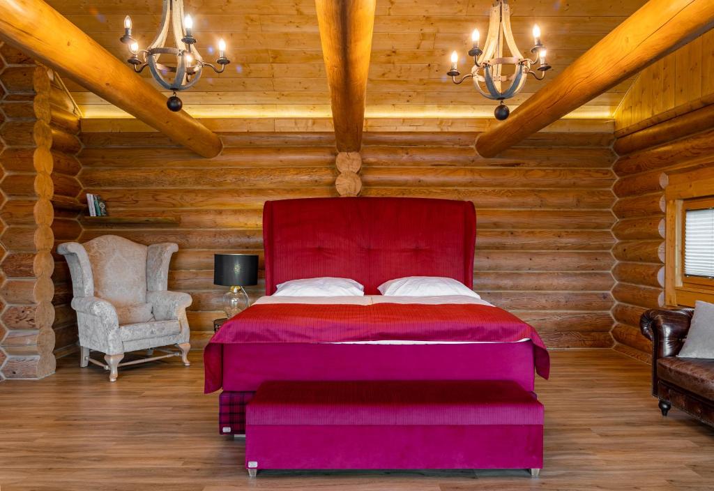 a bedroom with a red bed and a chair at Tatranský Zrub in Starý Smokovec