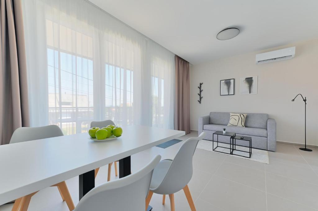una sala de estar blanca con mesa y sillas en Villa Oliver Zalakaros, en Zalakaros