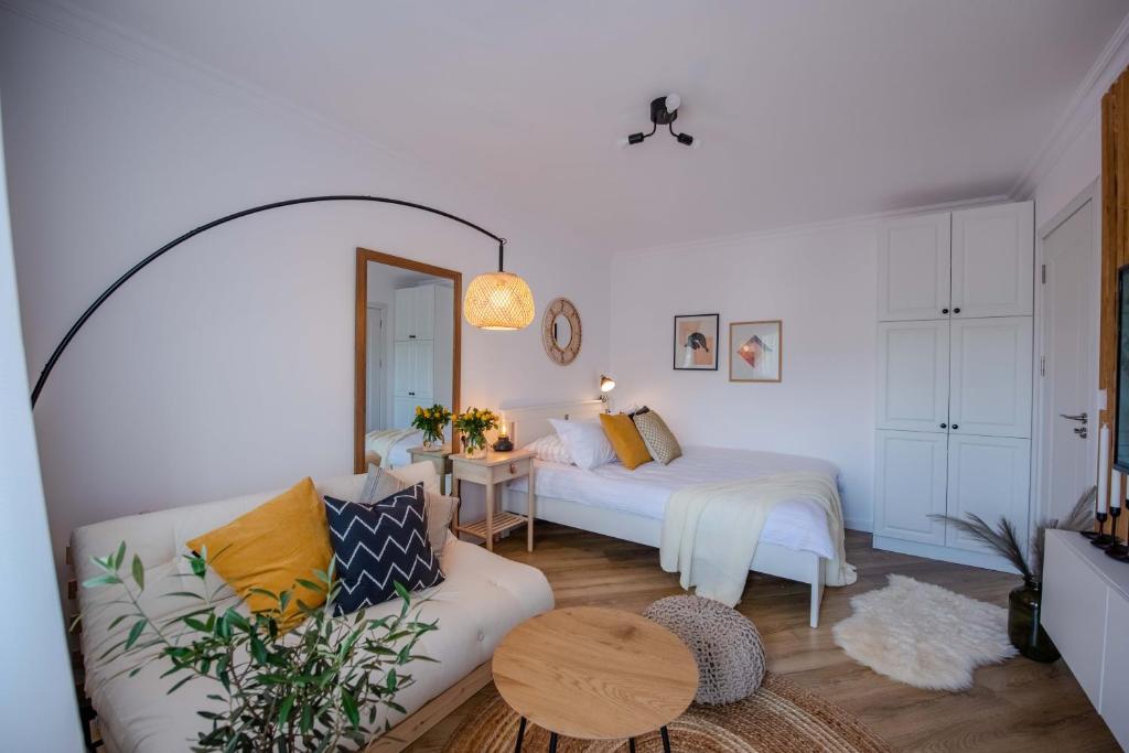 uma sala de estar com uma cama e um sofá em Cozy Little Place em Sighetu Marmaţiei