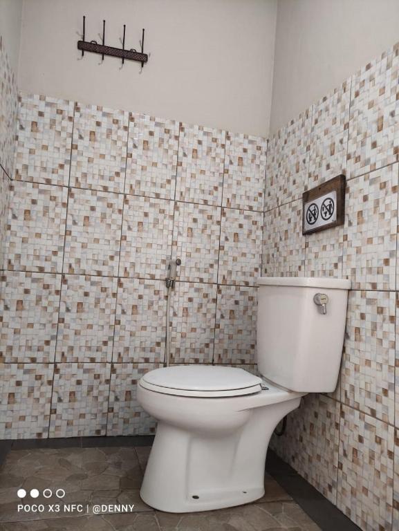 bagno con servizi igienici e parete piastrellata di Ecobromo a Pasuruan