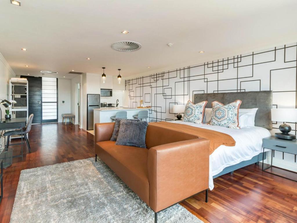 1 dormitorio con 1 cama grande y 1 sofá en Heriot Properties Units 19 & 20, en Johannesburgo