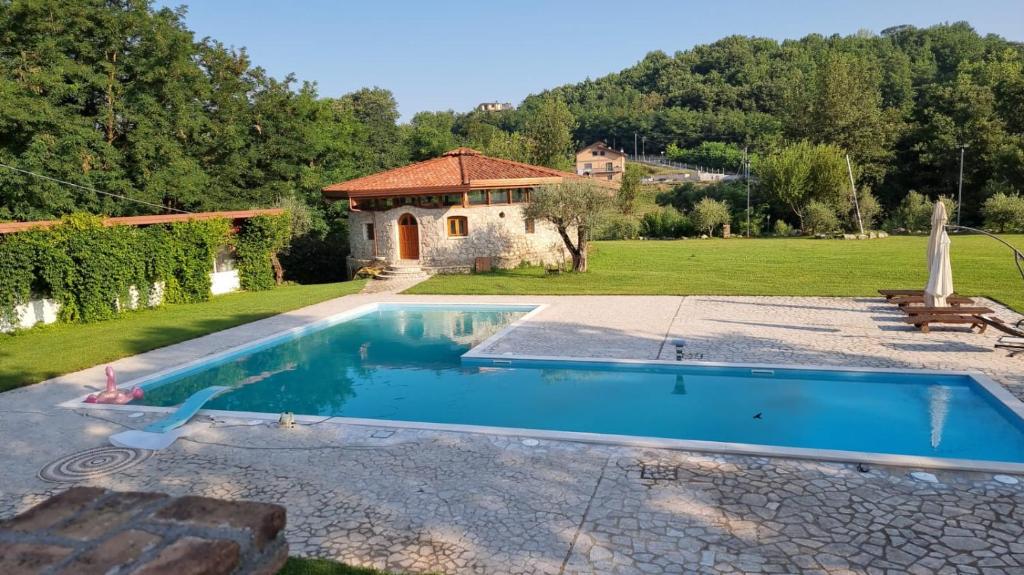 een zwembad in een tuin met een huis bij tenuta acquaviva in Pratola Serra