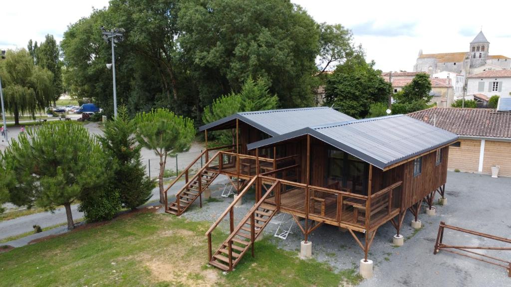 Una casa con escalera y techo solar. en Camping belle rivière, en Chaniers
