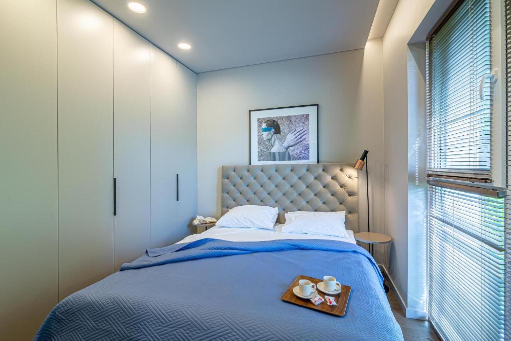une chambre avec un lit avec un plateau de nourriture dessus dans l'établissement Apartment w-Terrace I Air Condition I New building I Self Check-In, à Birštonas
