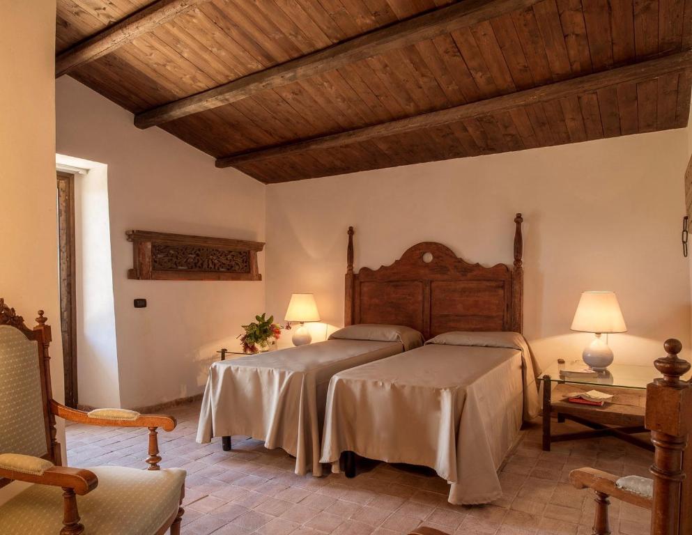 sypialnia z 2 łóżkami i drewnianym sufitem w obiekcie Luxury Sicily Villas by Geocharme w mieście Castelvetrano Selinunte