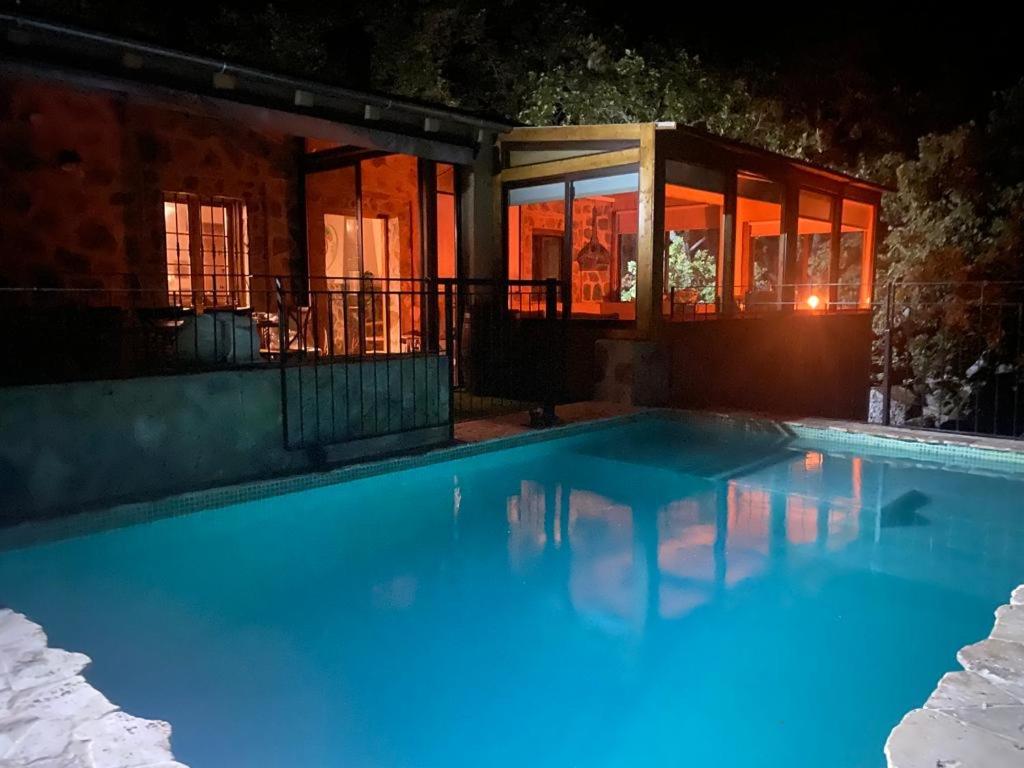 una piscina frente a una casa por la noche en Vuelos de Montaña l, en Montánchez