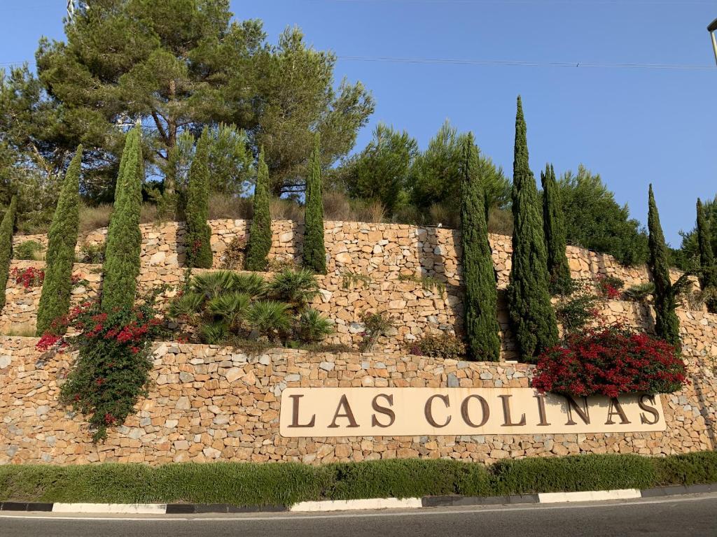 奧利維拉科斯塔的住宿－Las Colinas Golf - Naranjo 60 Penthouse，石墙,上面有读书的标志