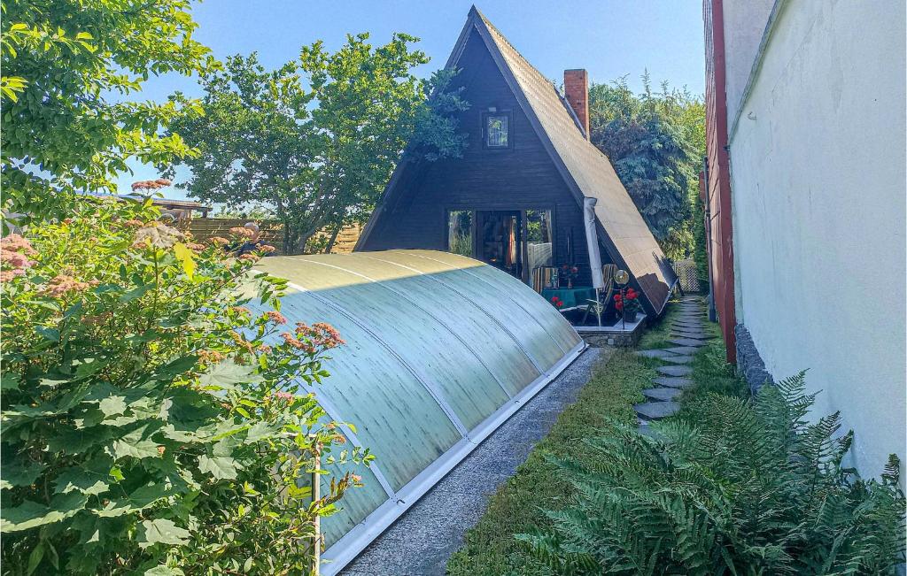 a house with a large greenhouse next to a yard at Amazing Home In Badersleben With 2 Bedrooms, Private Swimming Pool And Outdoor Swimming Pool in Badersleben