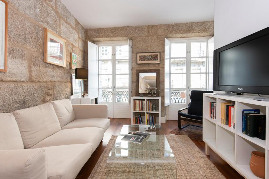a living room with a white couch and a tv at ELDUAYEN in Vigo