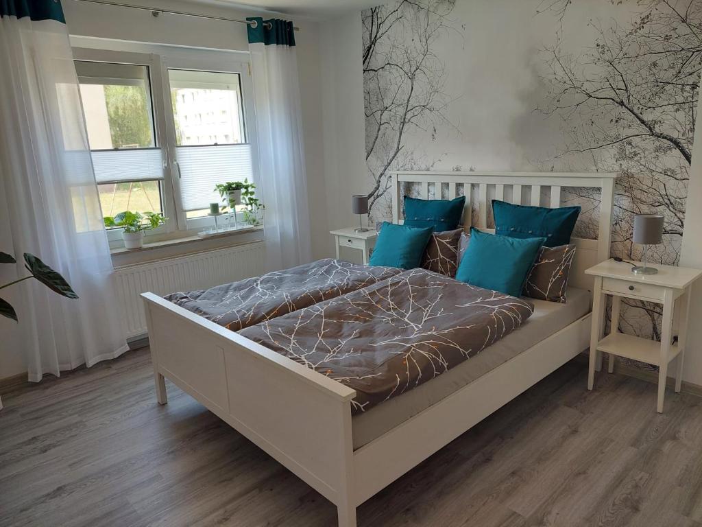 a bedroom with a large bed with blue pillows at Gemütliches, voll ausgestattetes Apartment in Halle an der Saale