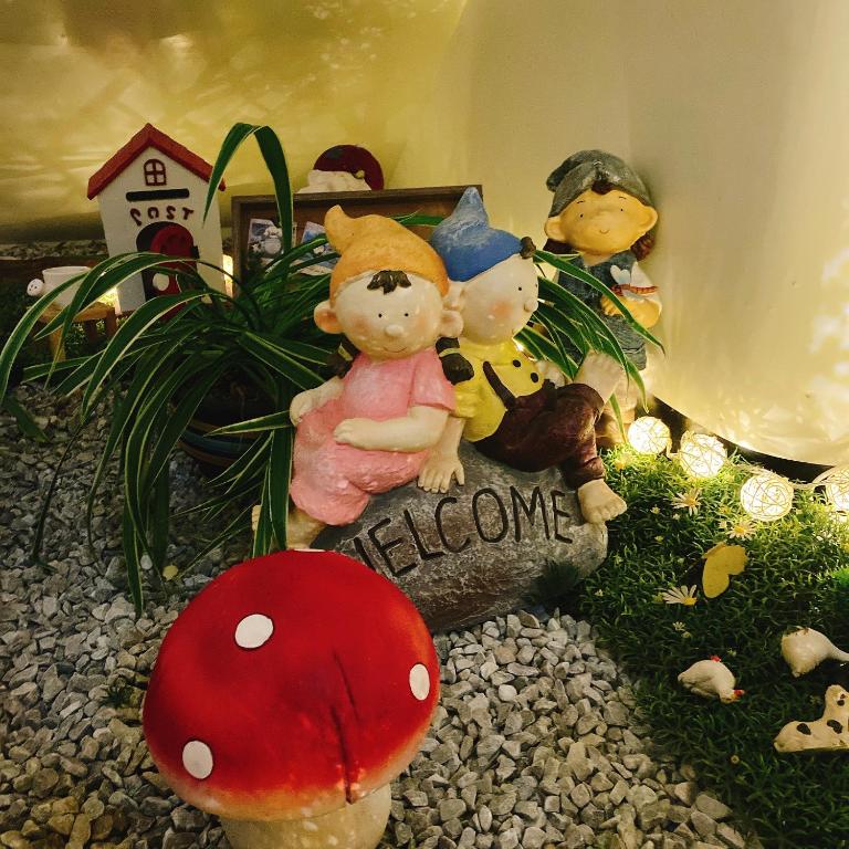 two stuffed animals sitting on a sign next to mushrooms at Full House in Jinning