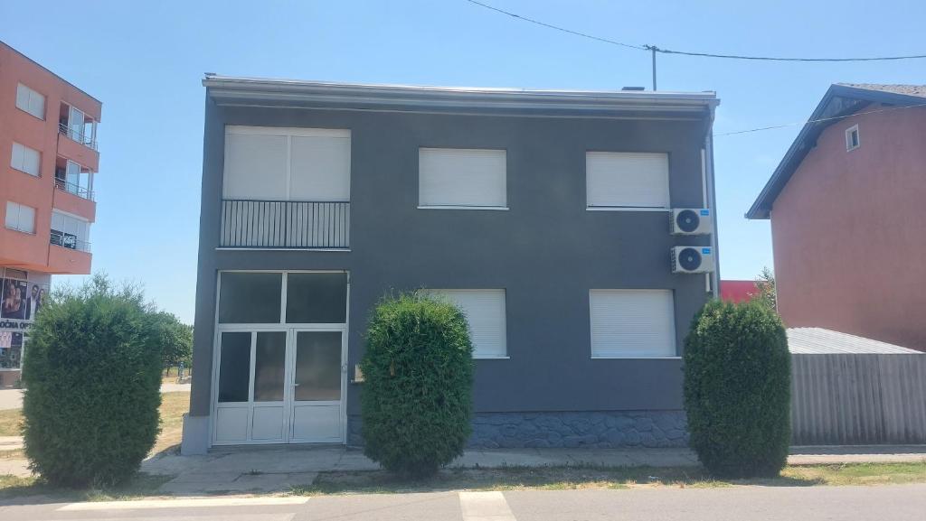 a black house with two bushes in front of it at FORUM apartmani i sobe in Donji Miholjac