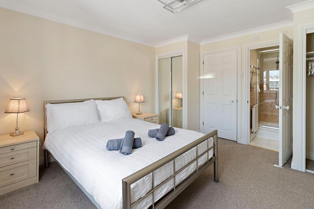 1 dormitorio con 1 cama con 2 toallas azules en Quayside House by Staytor Accommodation en Exeter
