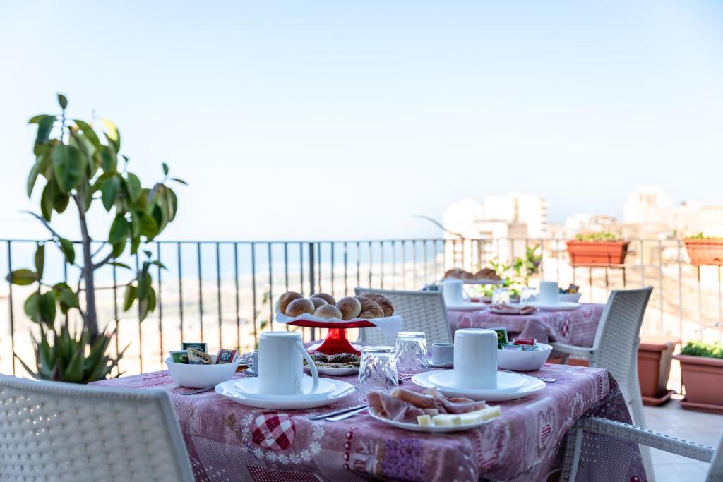 une table avec des assiettes de nourriture sur un balcon dans l'établissement B&B La veranda di Tatta, à Agrigente