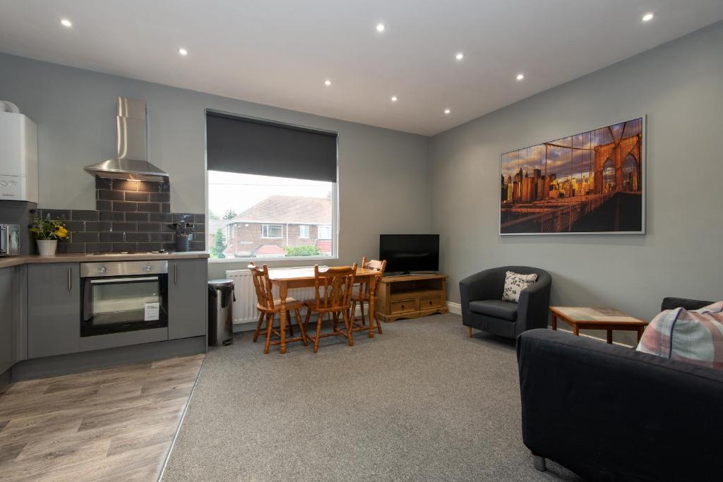a kitchen and living room with a table and chairs at Cosy, modern one bedroom apartment close to Durham in Bowburn