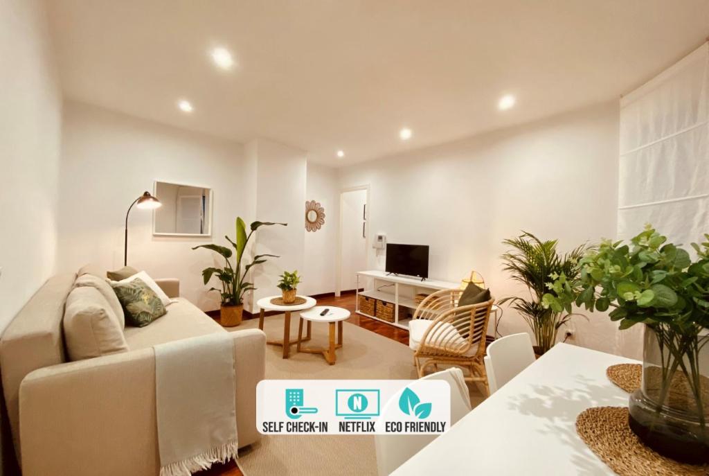 a living room with a couch and a tv at Quiet Marina Gardens Apartment in A Coruña