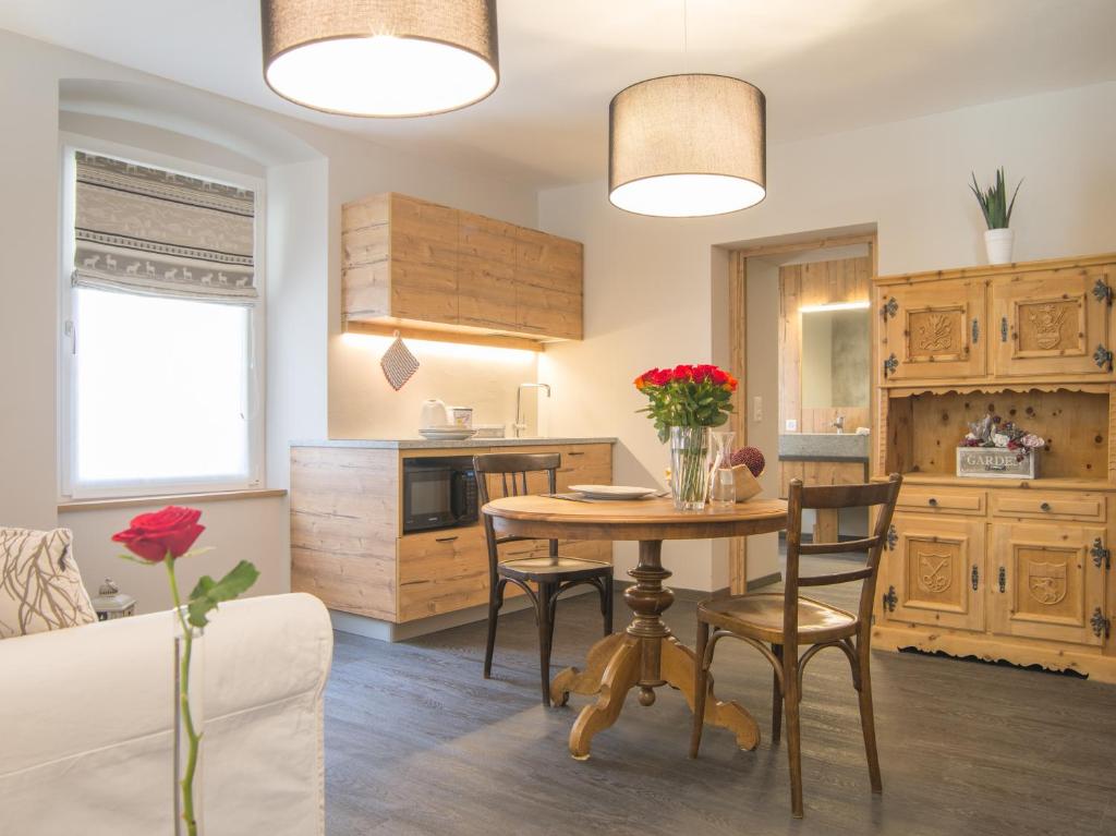 eine Küche und ein Esszimmer mit einem Tisch und Stühlen in der Unterkunft Hotel La Romantica in Le Prese, Poschiavo