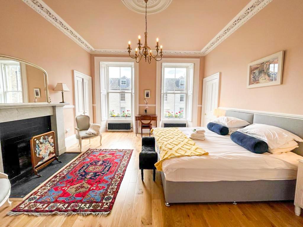 a bedroom with two beds and a fireplace at Remarkable 5BR Townhouse with Garden, Sleeps 12 in Edinburgh