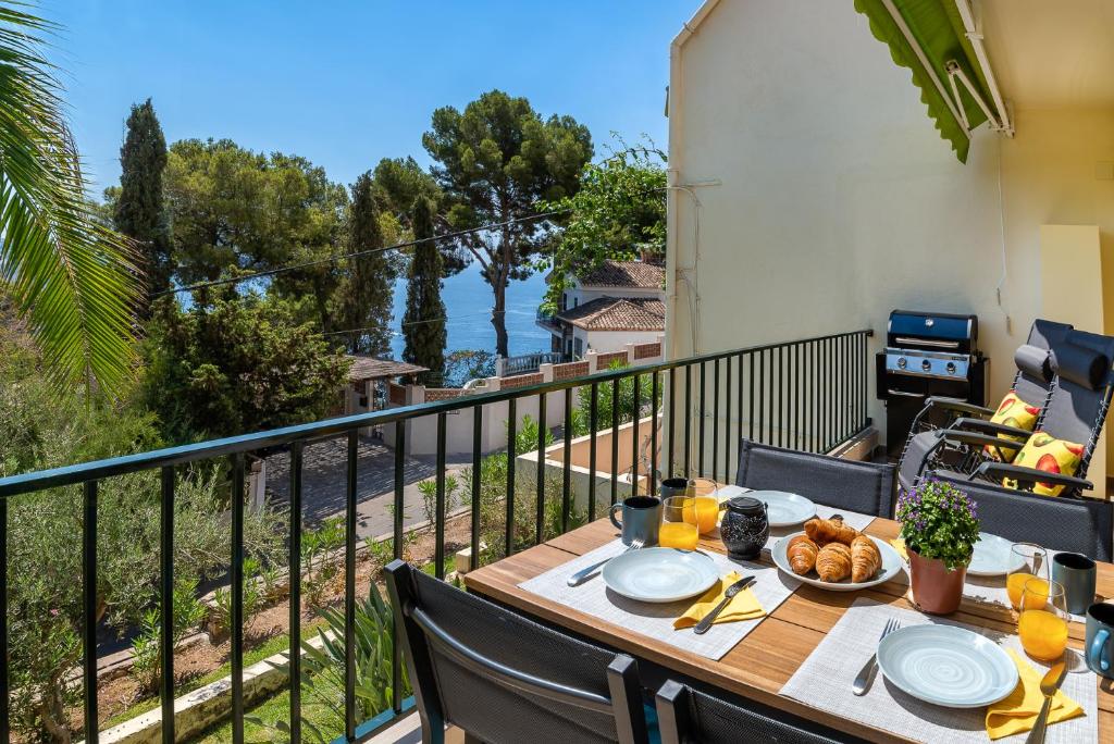 una mesa en un balcón con vistas al océano en Casa Viva la Vida en La Herradura