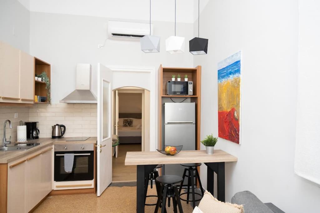 kuchnia ze stołem i krzesłami w pokoju w obiekcie HomeResidence 1 w mieście Ermupoli