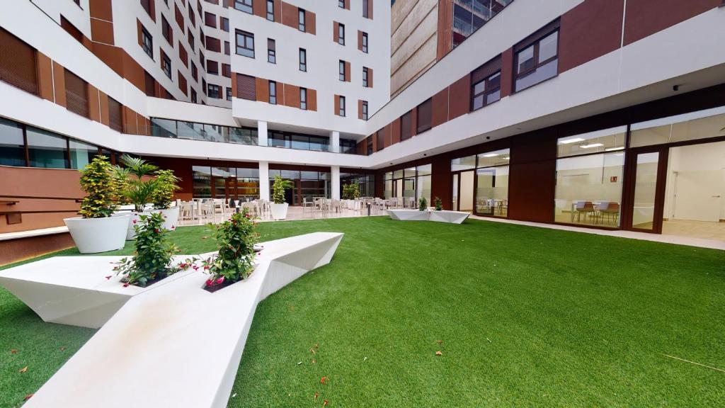 a large building with a green lawn in front of it at micampus Avenida del Puerto - Residencia de Estudiantes in Valencia