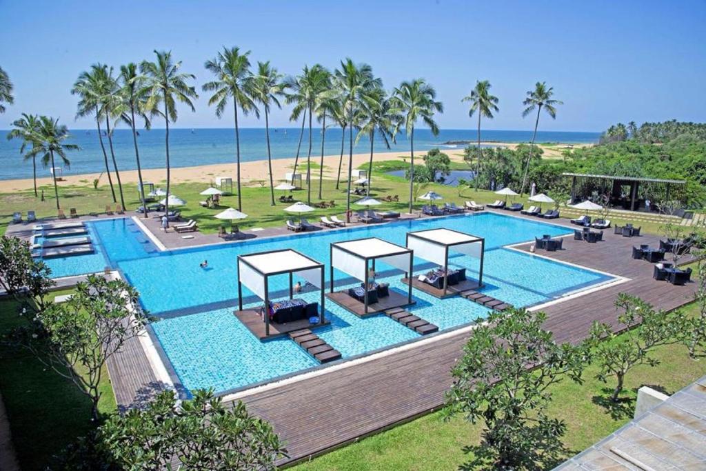 an overhead view of a pool with palm trees and the ocean at Suriya Resort in Wayikkal