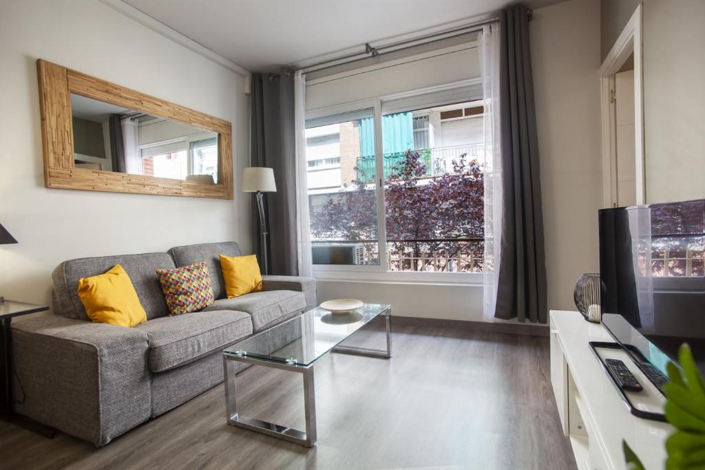 P9mdr1070 - Nice apartment in Poble Sec في برشلونة: غرفة معيشة مع أريكة وتلفزيون